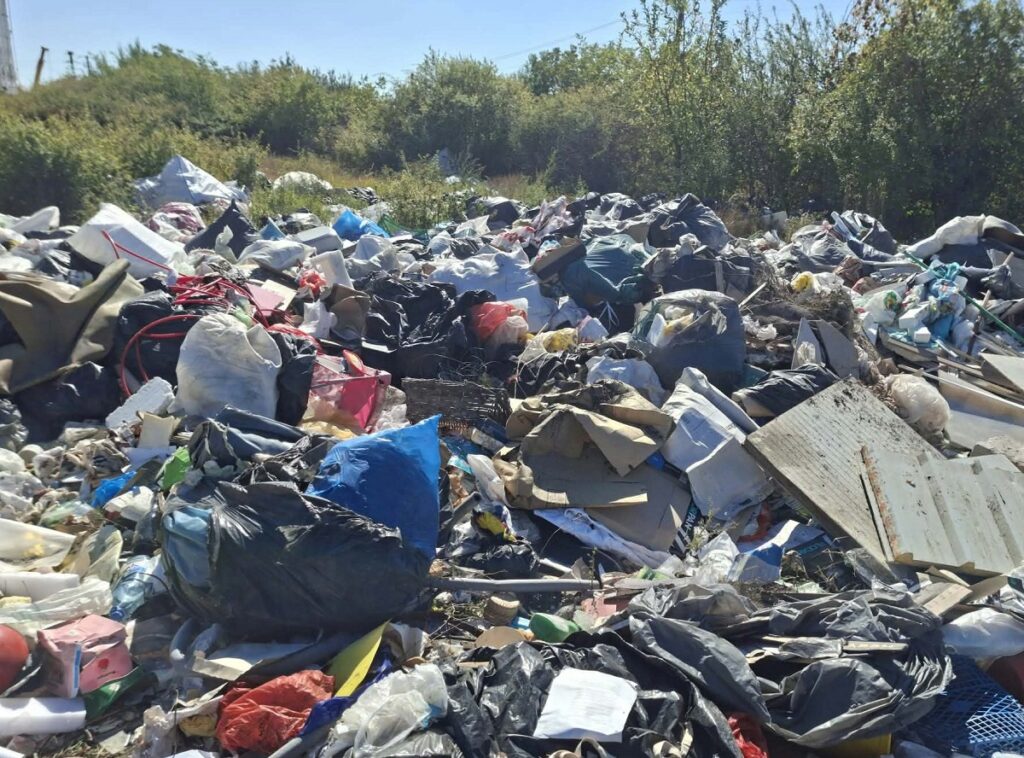 Deșeuri abandonate pe un teren viran: saci, plastic și resturi menajere aruncate la grămadă
