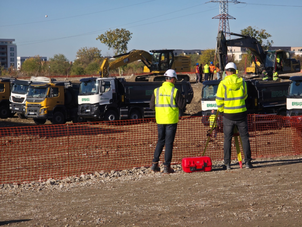 muncitori cu veste reflectorizante și utilaje Erbașu pe un șantier de construcție