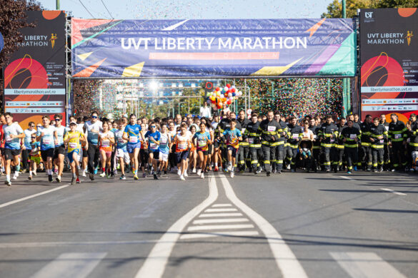 start UVT Liberty Marathon, mulțime de alergători sub arcul de start cu confeti start UVT Liberty Marathon, mulțime de alergători sub arcul de start cu confeti